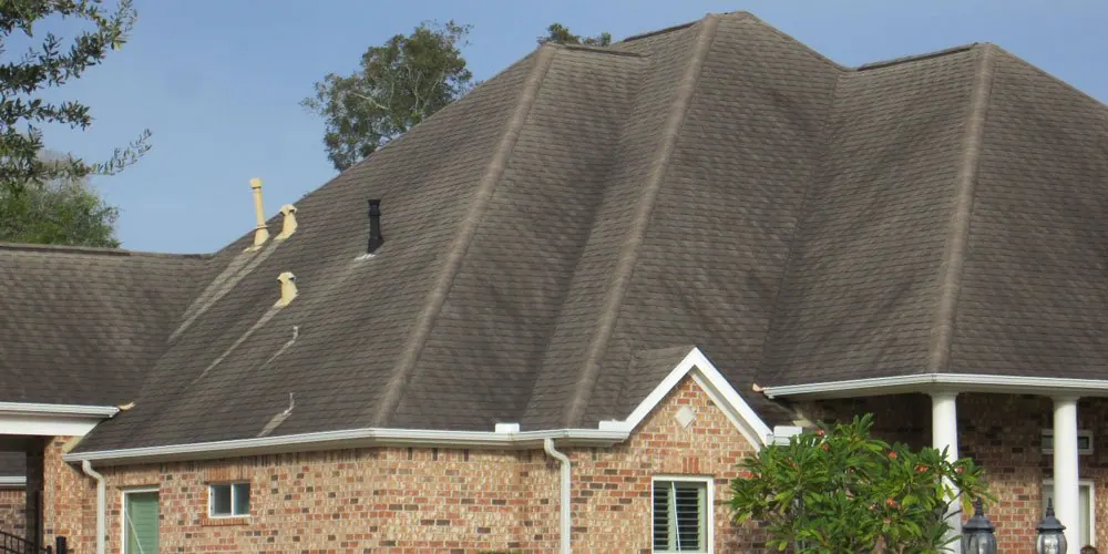 Asphalt shingle roof edge and gutter during roof cleaning