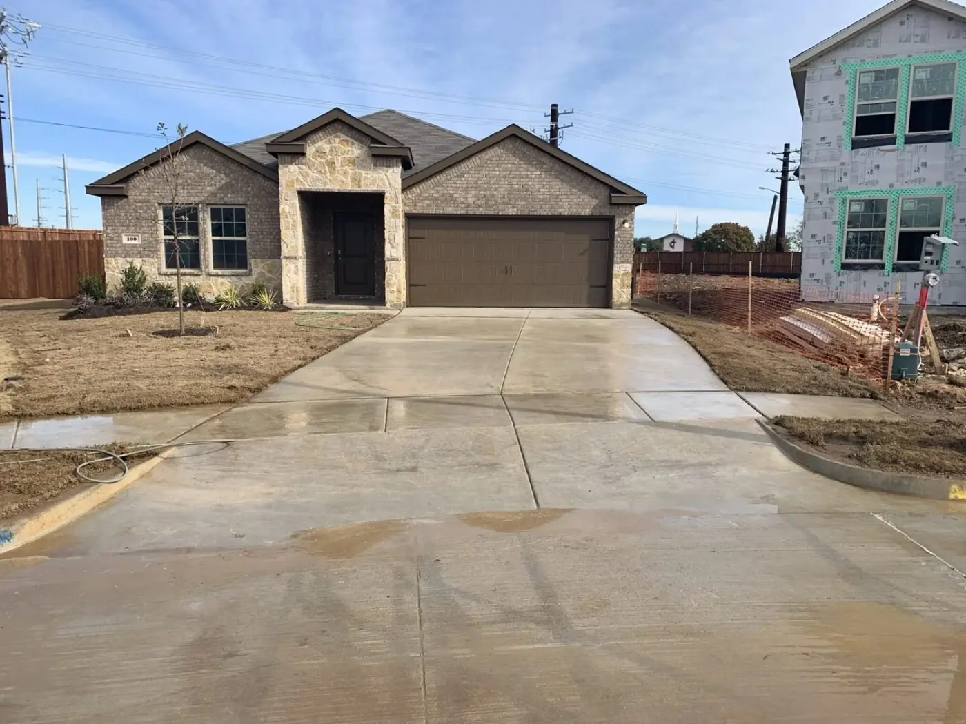 New construction home with a freshly cleaned concrete driveway