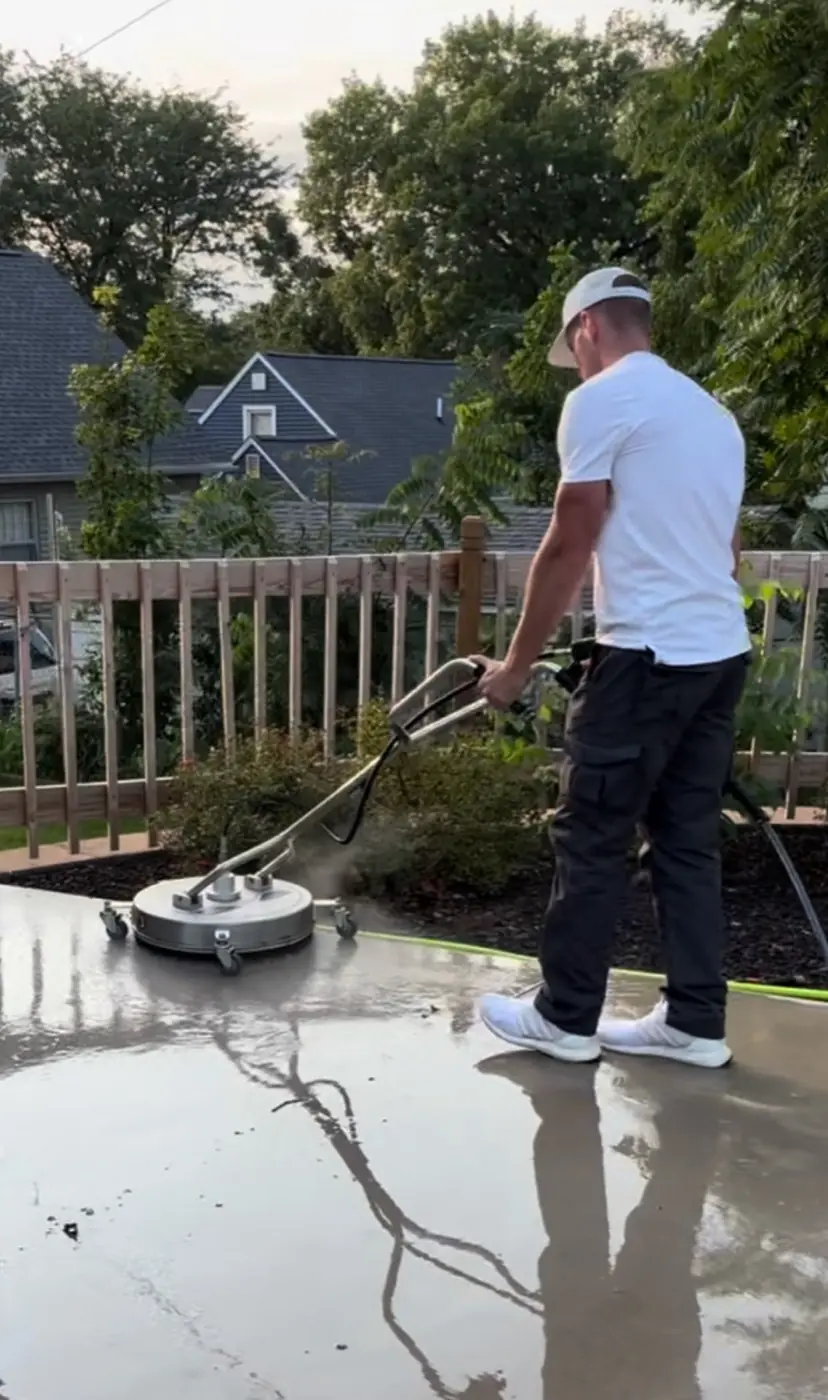 SurfacePro technician using a power scrubber on a wet concrete patio